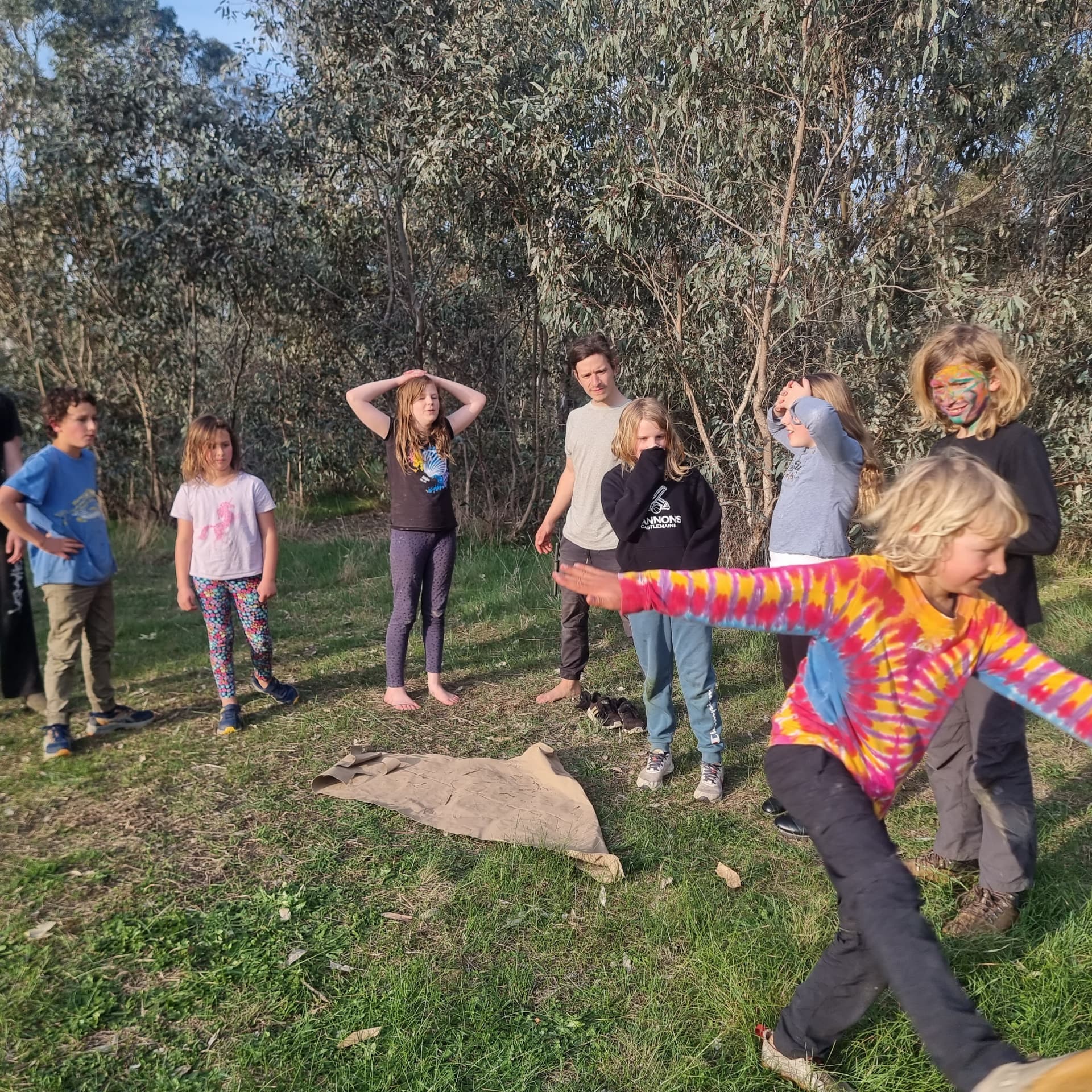 Kids playing a running game with painted faces at a bush session