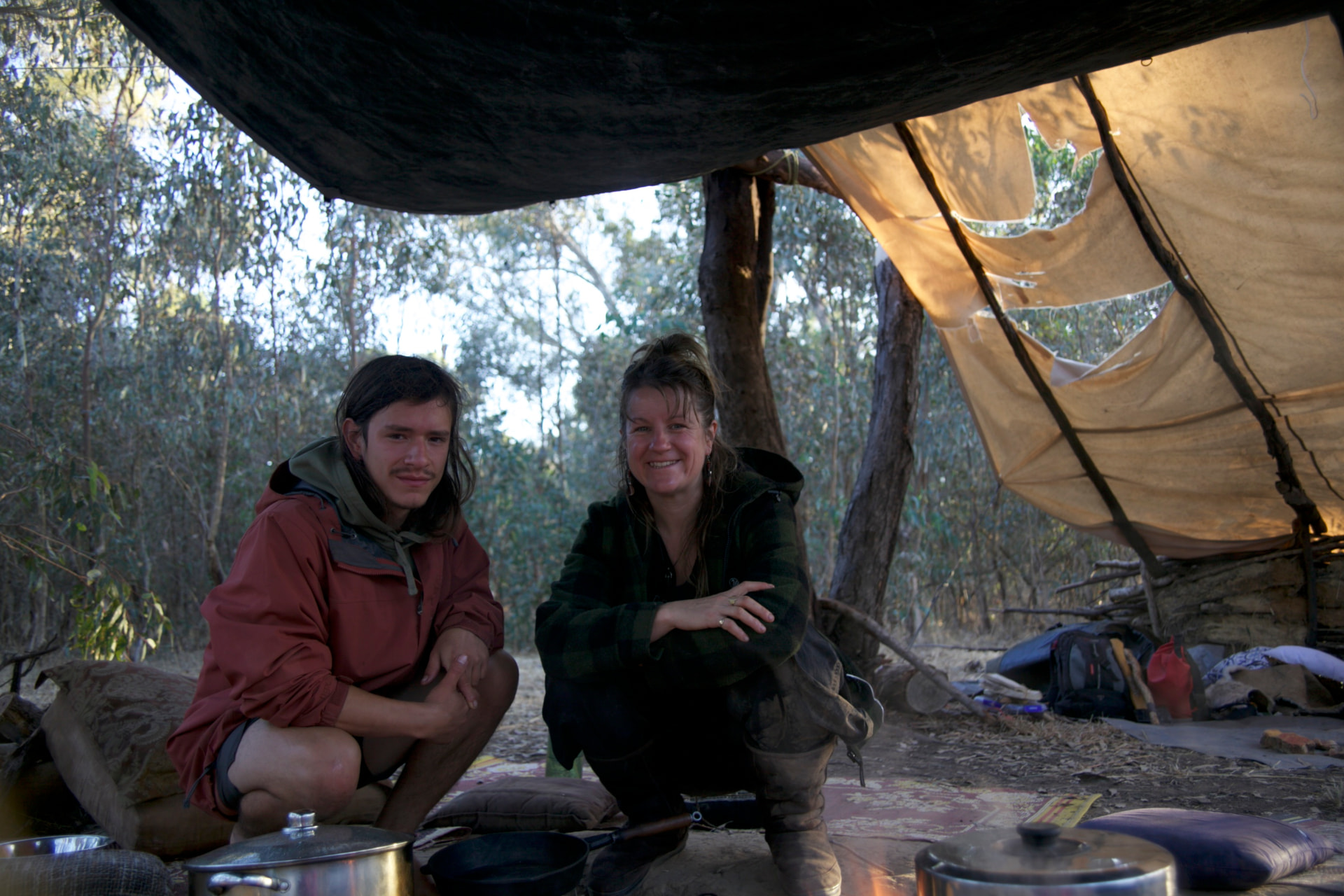 Nectar and Cesar sitting in a bush shelter at golden hour
