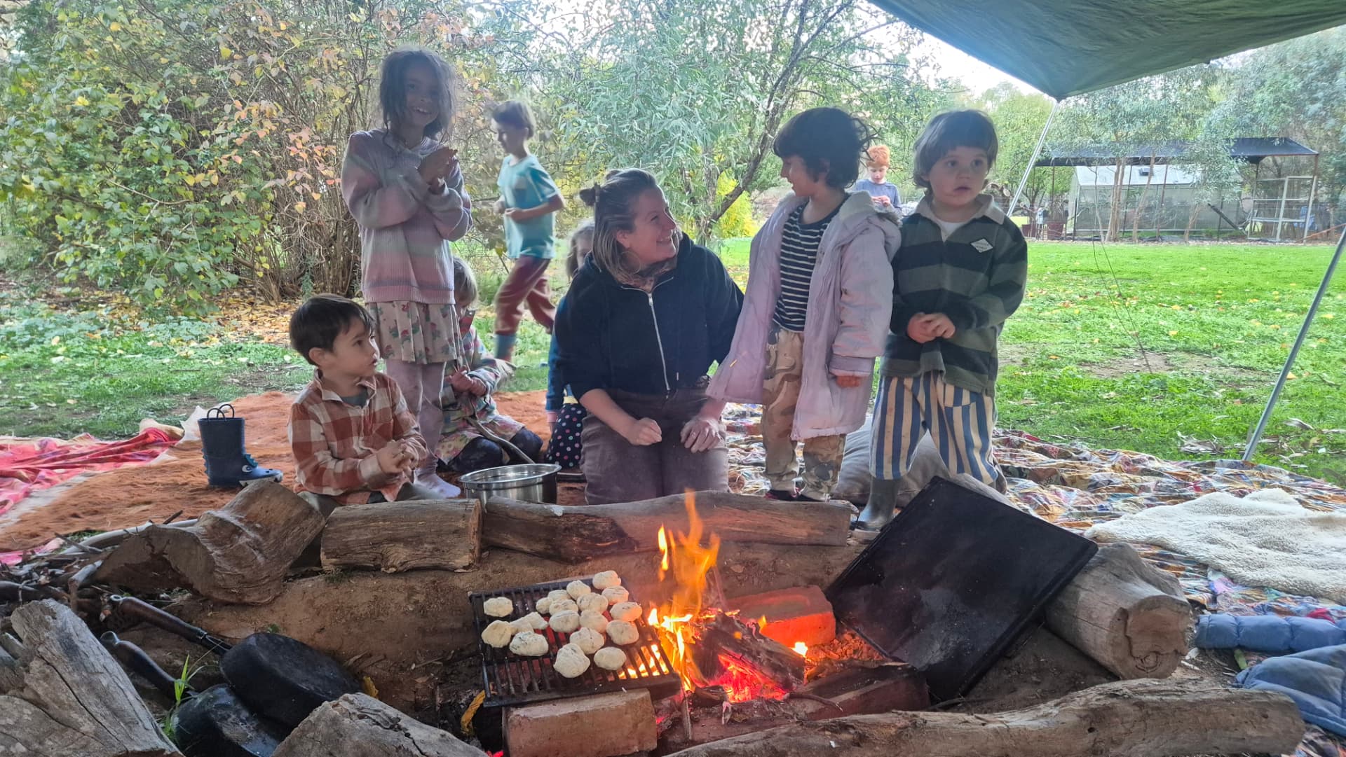Little ones around the fire while damper cooks on the grill